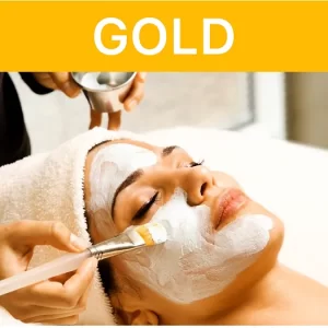 Woman receiving a gold facial treatment in a serene spa setting.