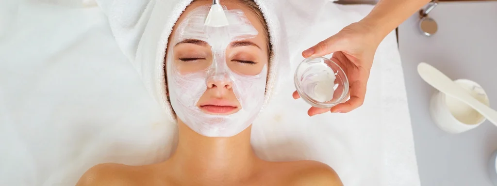 Rejuvenating facial treatment at a spa with soothing white cream applied to a woman's face.