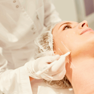 A beautician applies a treatment on a woman's face during a spa session.