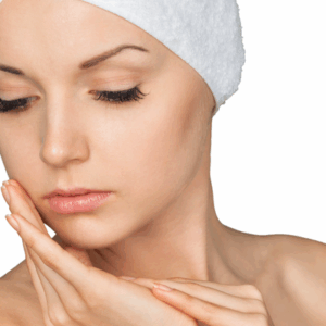 A woman in a spa headband gently touching her face, showcasing radiant skin and relaxation.