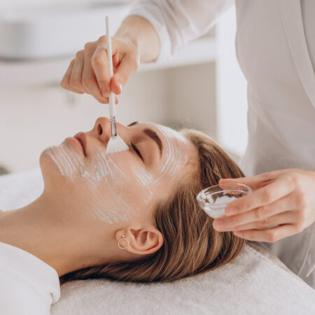 Relaxing facial treatment with a spa professional applying a mask to a client's face.