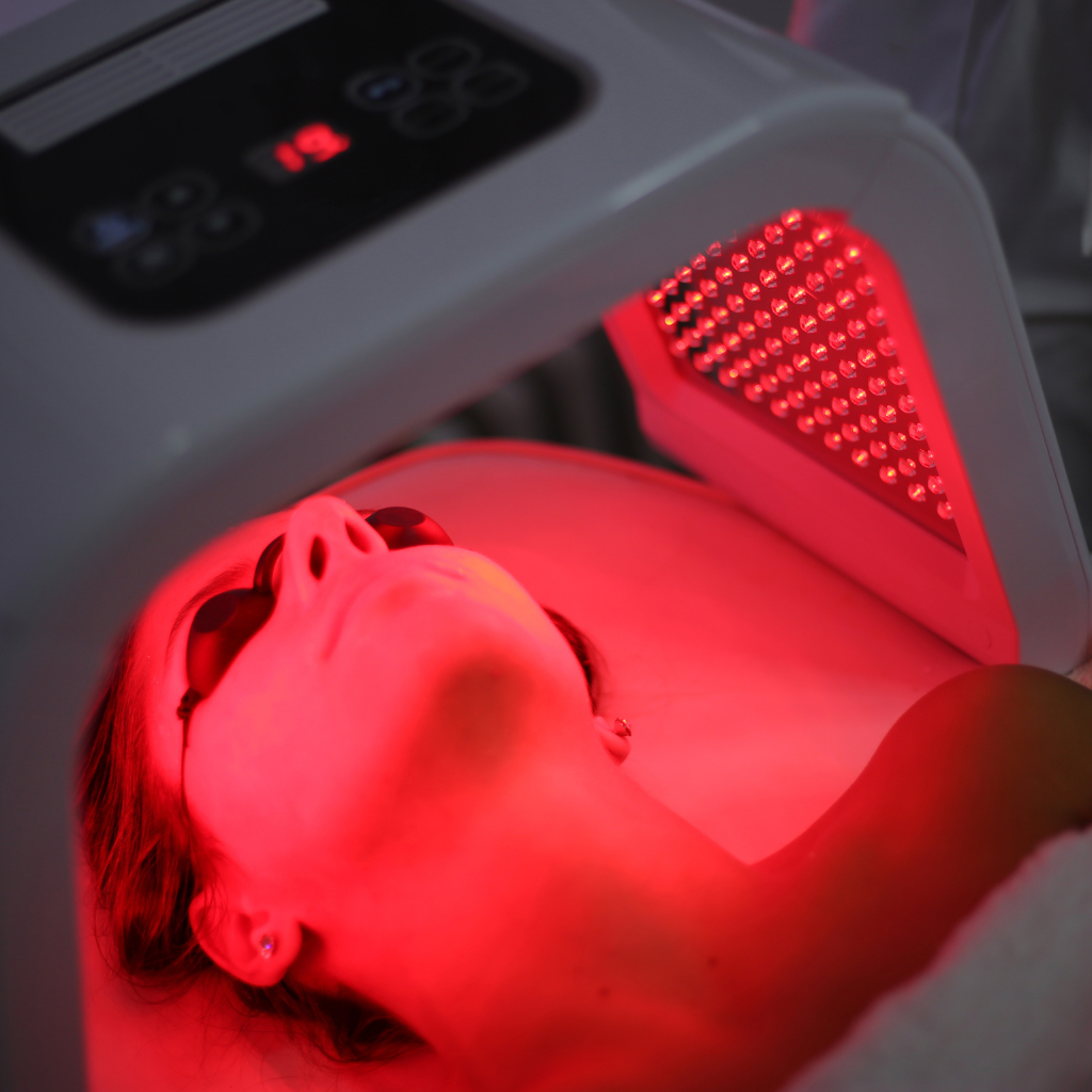 Person undergoing red light therapy session for skin rejuvenation.